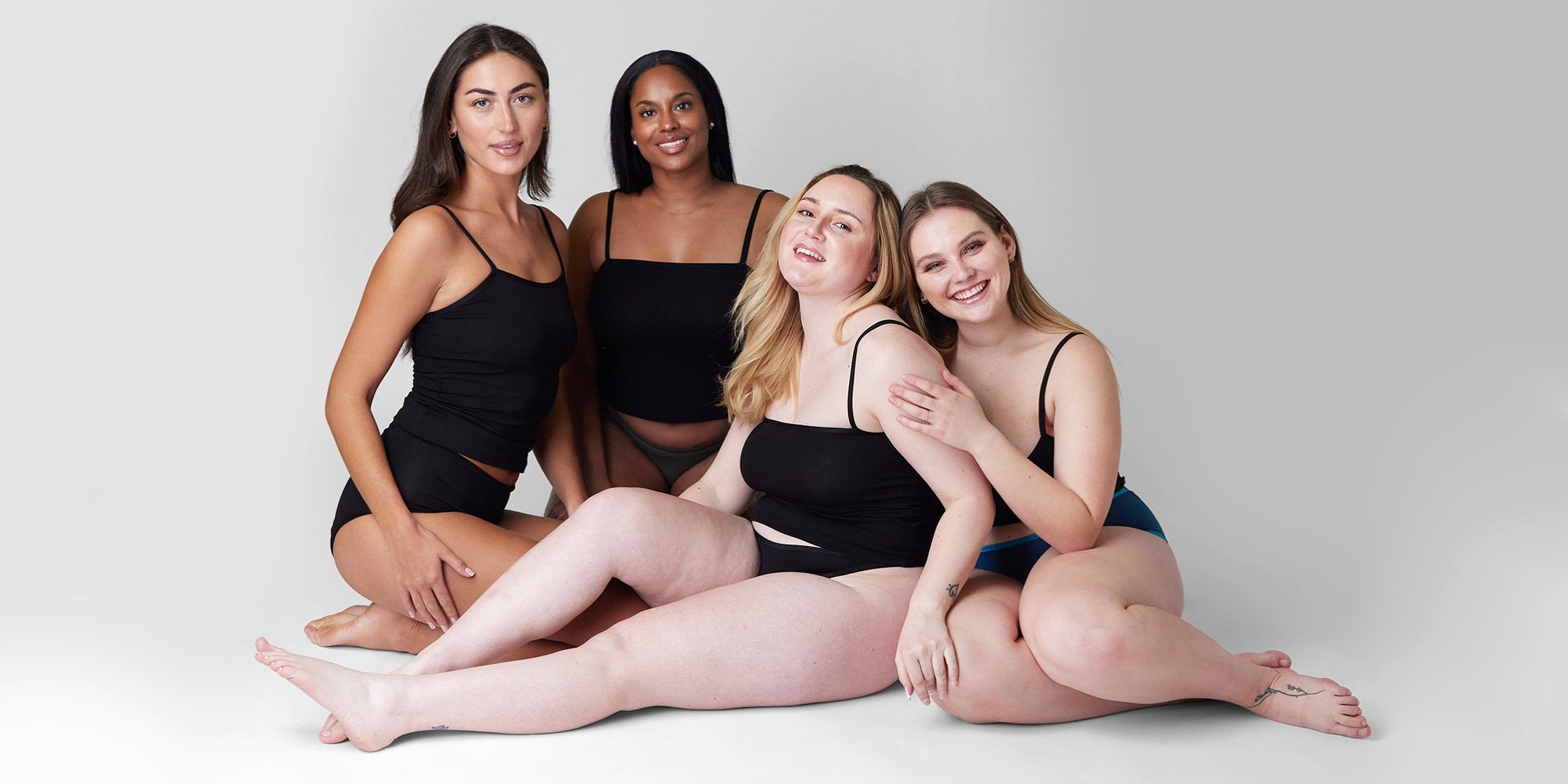 4 models sat on the floor in period pants for the blog how do period pants work? a guide on how they'll change your life