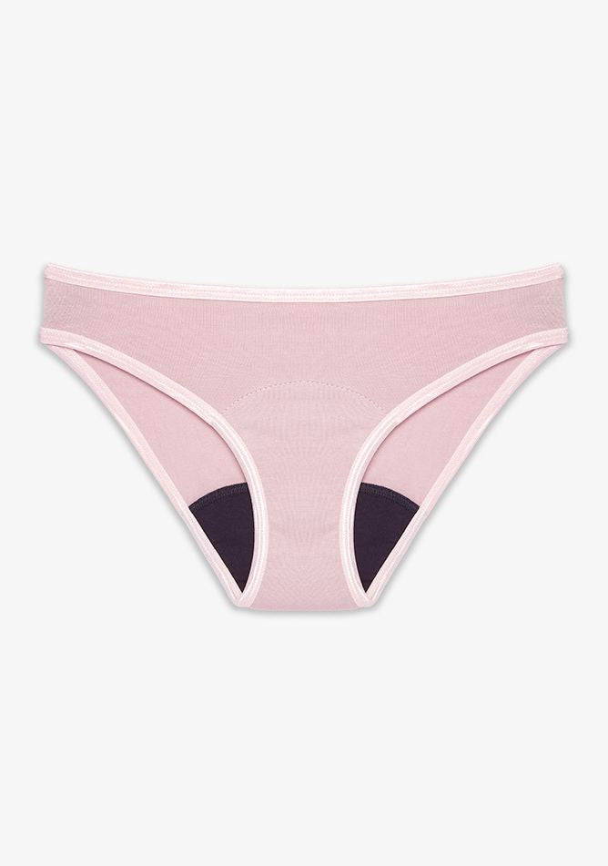 Bikini style underwear in a soft blush pink color. It features matching pink trim around the waistband and leg openings. The inner gusset is dark colored, indicating an absorbent layer likely meant for period protection or moisture-wicking. The fabric appears smooth and stretchy, designed for comfort and daily wear. The overall look is feminine, functional, and minimalist.