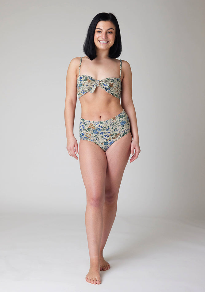 Front image of a five-foot-six, size 8 model wearing Ugly Pants' Cream Floral Print Overnight period pants in moderate to heavy absorbency, paired with a cream floral print crop top, featuring a self tie detachable bow.
