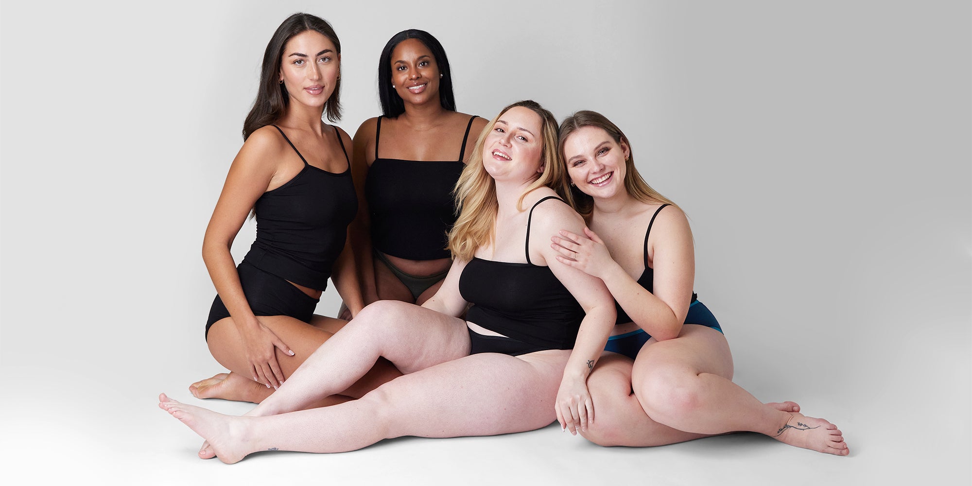 4 models sat on the floor in period pants for the blog how do period pants work? a guide on how they'll change your life