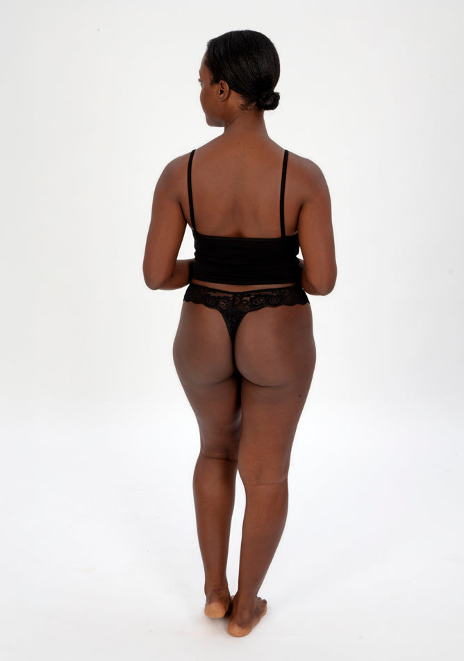 Back image of a five foot four, size 1o model wearing Ugly Pants' Black Lace Thong period pants in a light absorbency, paired with a black crop top.