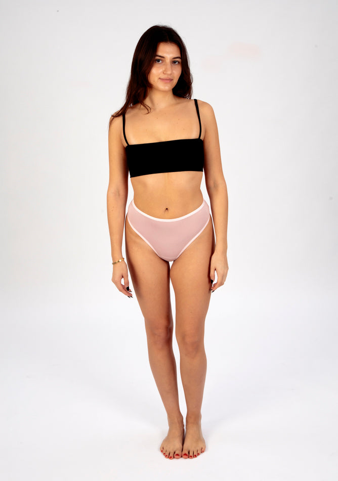 Front image of a five foot six, size 8 model wearing Ugly Pants' blush high waisted period thong in light absorbency, paired with a black crop top.