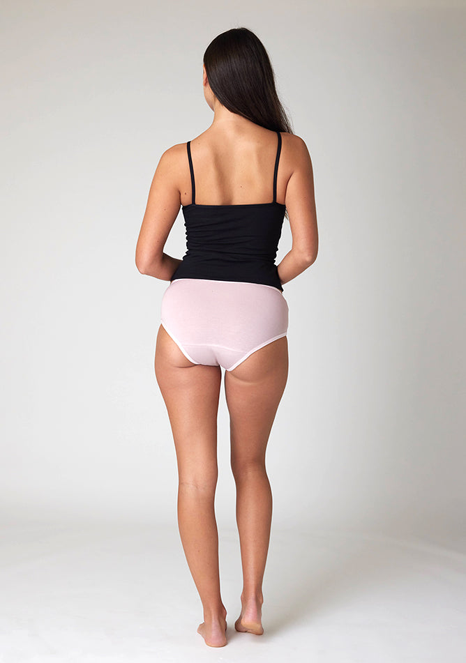 Back image of a five foot nine, size 8 model wearing Ugly Pants' Blush Hipster Brief Period Pants in moderate to heavy absorbency, paired with a black cami top