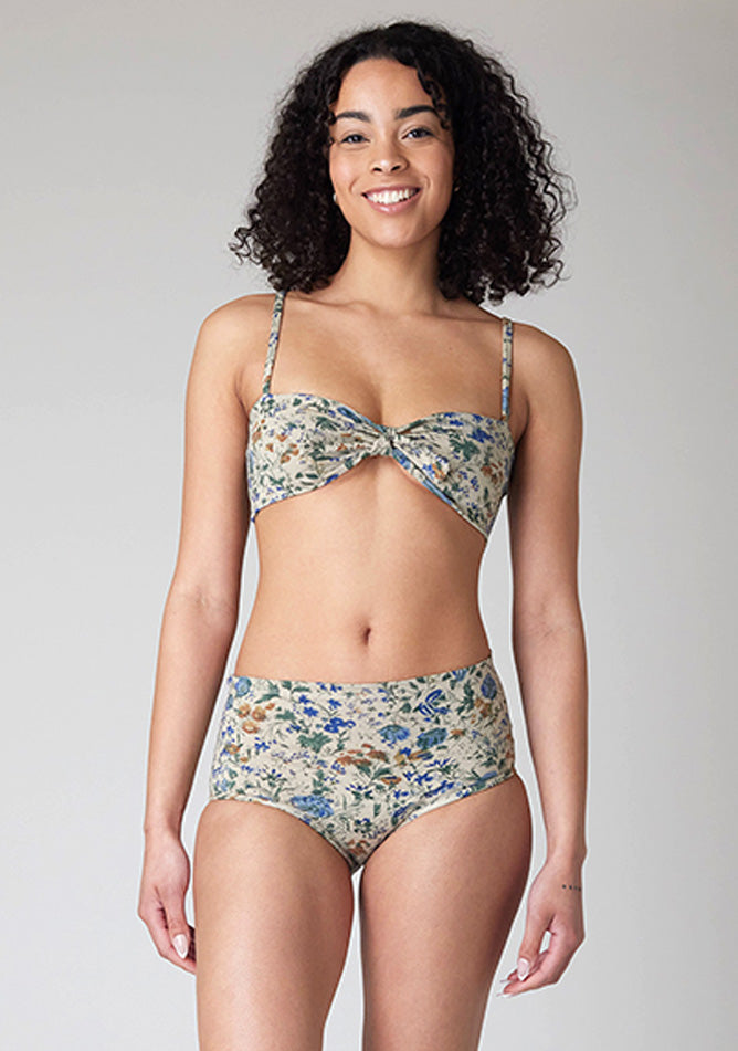 Close up image of a five-foot-ten, size 10 model wearing Ugly Pants' Cream Floral Print Overnight period pants in moderate to heavy absorbency, paired with a cream floral print crop top, featuring a self tie detachable bow.