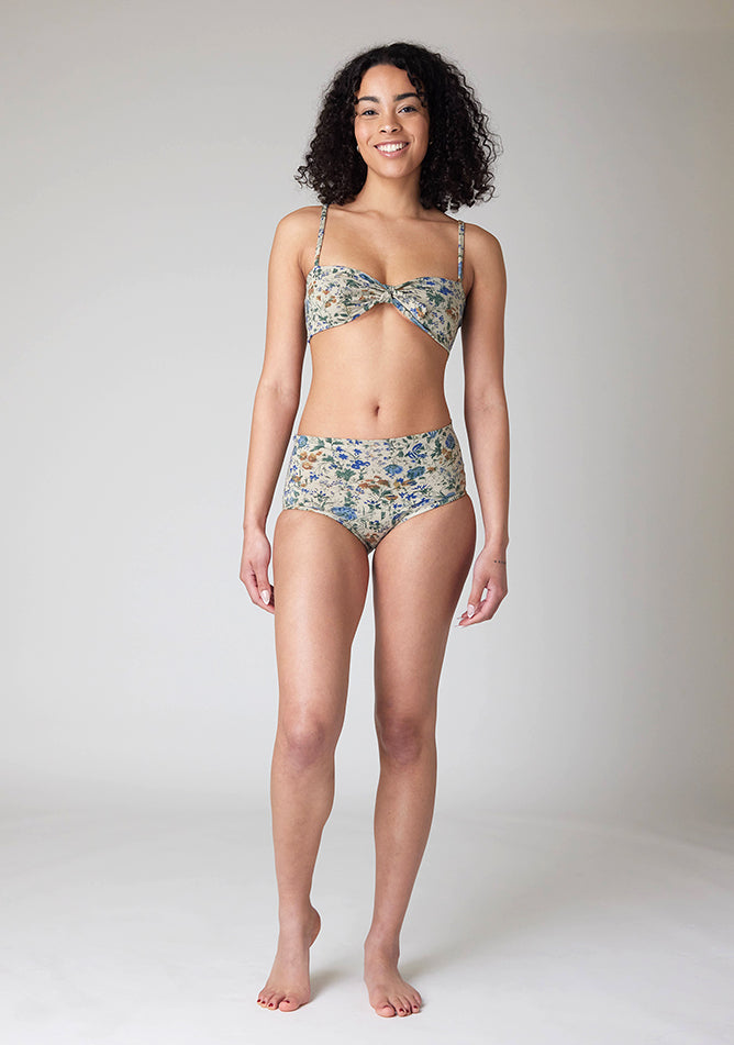 Front image of a five-foot-ten, size 10 model wearing Ugly Pants' Cream Floral Print Overnight period pants in moderate to heavy absorbency, paired with a cream floral print crop top, featuring a self tie detachable bow.