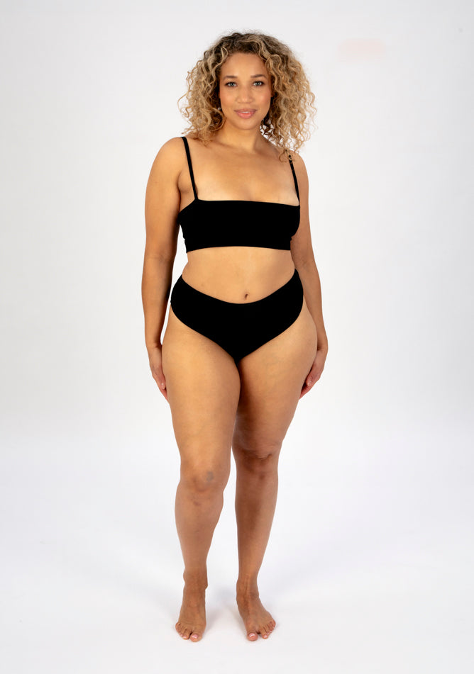 Front image of a five foot sveen, size 16 model wearing Ugly Pants' Black Lace High Waisted Period Pant in a light to moderate absorbency, paired with a black crop top.