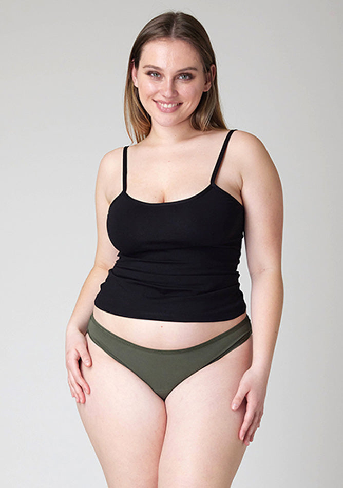 Close up image of a five-foot-five, size 14 model wearing Ugly Pants' Olive Bikini Brief period Pants in light to moderate absorbency, paired with a black cami top