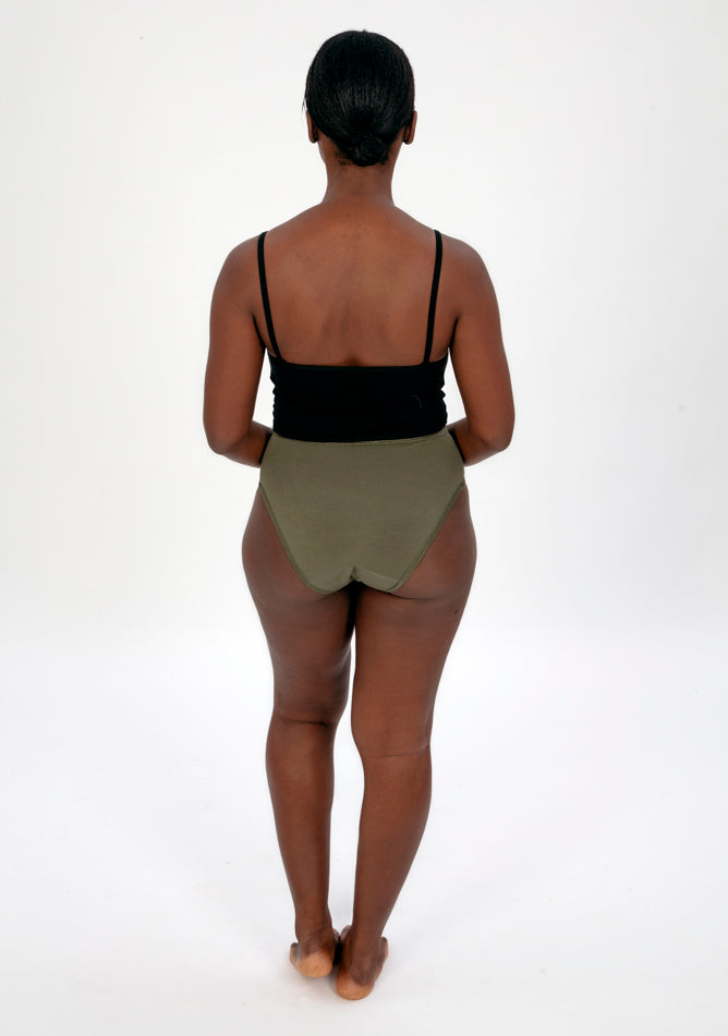 Back image of a five foot four, size 10 model wearing Ugly Pants' olive high waisted period pants in light to moderate absorbency, paired with a black crop top.