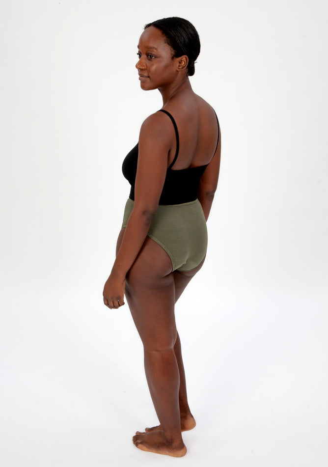 Back quarter image of a five foot four, size 10 model wearing Ugly Pants' olive high waisted period pants in light to moderate absorbency, paired with a black crop top.