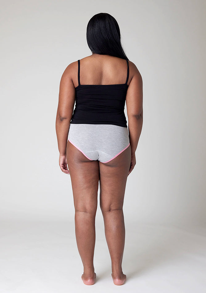 Back image of a five foot five, size 10 model wearing Ugly Pants' Grey Hipster Brief Period Pants with light pink elastic in moderate to heavy absorbency, paired with a black cami top