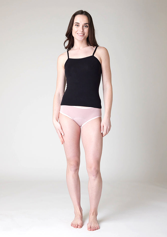 Front image of a five foot nine, size 8 model wearing Ugly Pants' Blush Hipster Brief Period Pants in moderate to heavy absorbency, paired with a black cami top