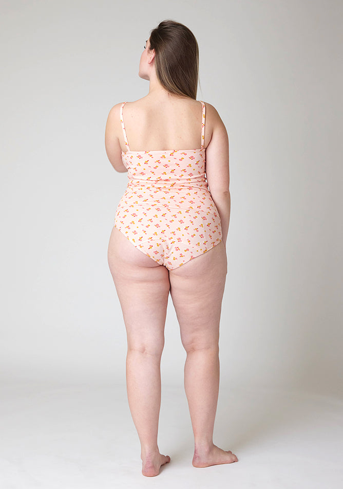 Back image of a five foot five, size 14 model wearing Ugly Pants' Pink Floral Print Overnight flow sleep set with matching pink floral print cami