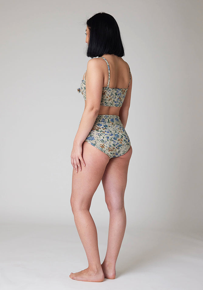 Back front image of a five foot six, size 8  model wearing Ugly Pants' Cream Floral Print Overnight flow sleep set with matching cream floral print crop top, featuring a self tie detachable bow.