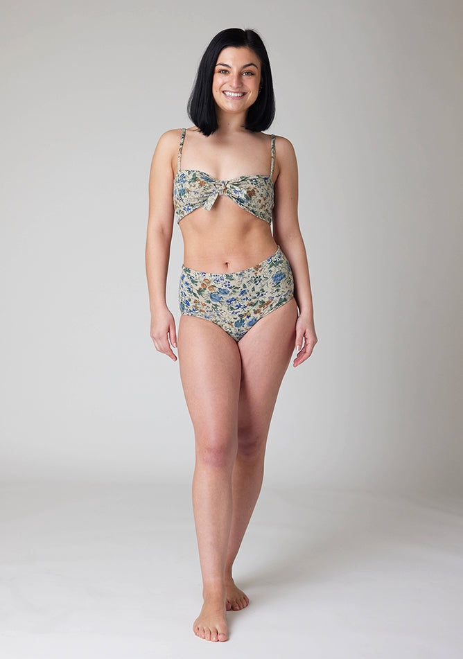 Front image of a five foot six, size 8 model wearing Ugly Pants' Cream Floral Print Overnight flow sleep set with matching cream floral print crop top, featuring a self tie detachable bow.