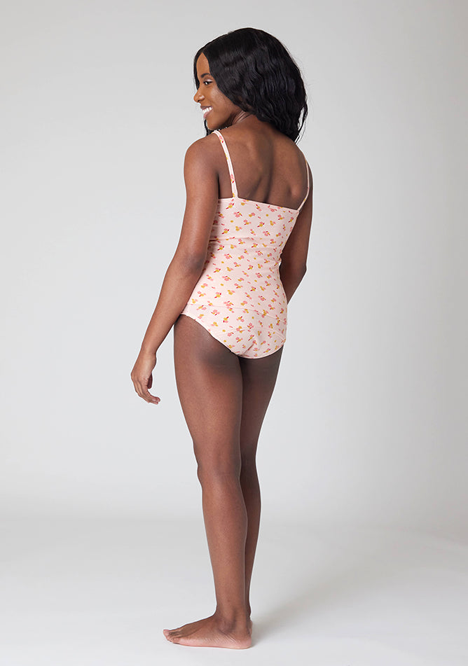 Back quarter image of a five foot, size 6 model wearing Ugly Pants' Pink Floral Print Overnight flow sleep set with matching pink floral print cami
